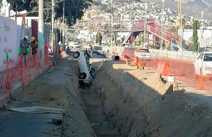 Coche particular en una zanja por trabajos de construcción en Rio de las Avenidas